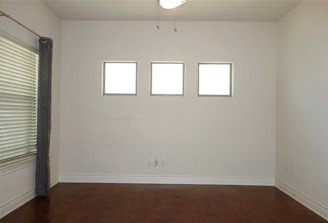 empty room featuring baseboards and wood finished floors