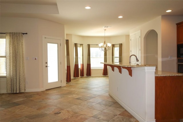 kitchen with visible vents, black microwave, pendant lighting, light stone counters, and recessed lighting