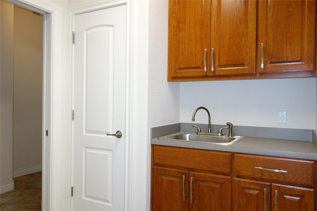 kitchen with light countertops, brown cabinets, and a sink