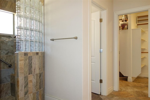 bathroom featuring a spacious closet and a walk in shower