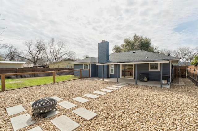 10113 Quail Hutch Dr, Austin, TX 78758 - back of house featuring a fire pit, a patio area, a chimney, a fenced backyard, and roof with shingles