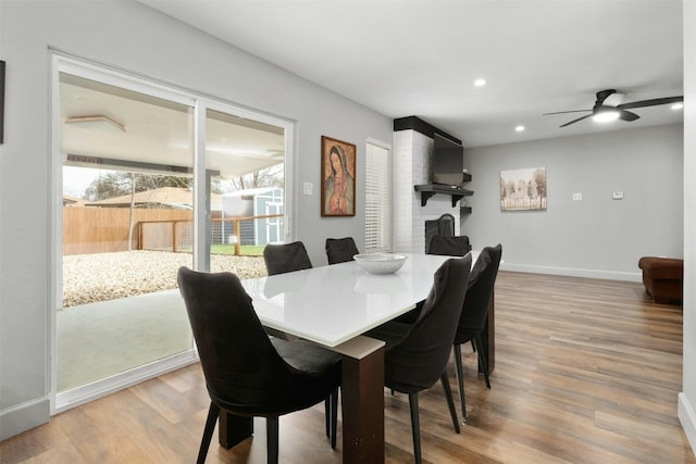 10113 Quail Hutch Dr, Austin, TX 78758 - dining room featuring a ceiling fan, wood finished floors, baseboards, recessed lighting, and a brick fireplace