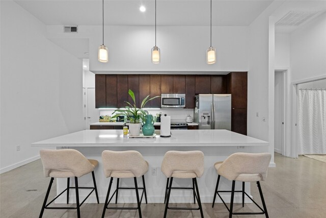 507 Sabine St Unit 907, Austin, TX 78701 - kitchen featuring appliances with stainless steel finishes, light countertops, finished concrete flooring, and dark brown cabinets