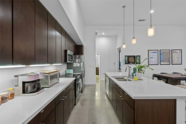 507 Sabine St Unit 907, Austin, TX 78701 - kitchen with appliances with stainless steel finishes, a sink, finished concrete flooring, light countertops, and a center island with sink