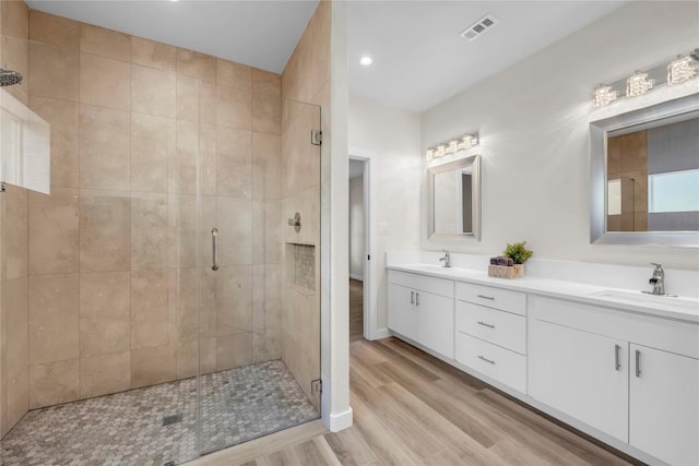 1514 Green Valley Ln, Granite Shoals, TX 78654 - bathroom featuring double vanity, a stall shower, wood finished floors, and recessed lighting