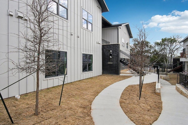 view of home's community with stairway, fence, and a lawn