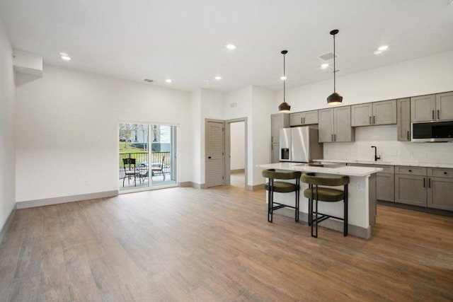 kitchen with tasteful backsplash, gray cabinets, stainless steel appliances, and a sink