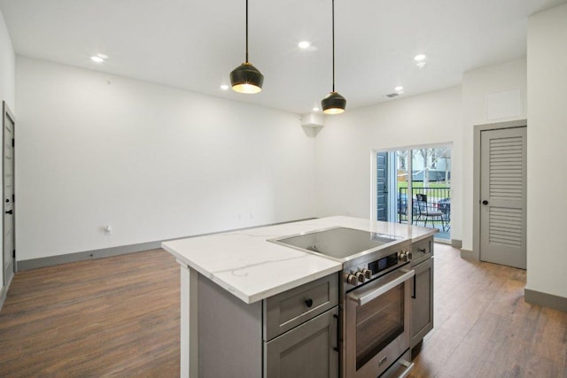 kitchen featuring stainless steel electric stove, pendant lighting, wood finished floors, and gray cabinetry