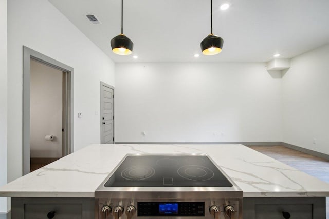 kitchen featuring light stone counters, recessed lighting, visible vents, hanging light fixtures, and cooktop