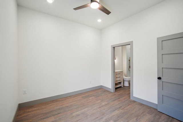 unfurnished bedroom with recessed lighting, wood finished floors, connected bathroom, and baseboards