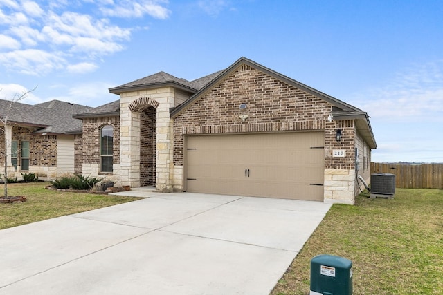 view of front of home featuring central AC, a garage, and a front lawn