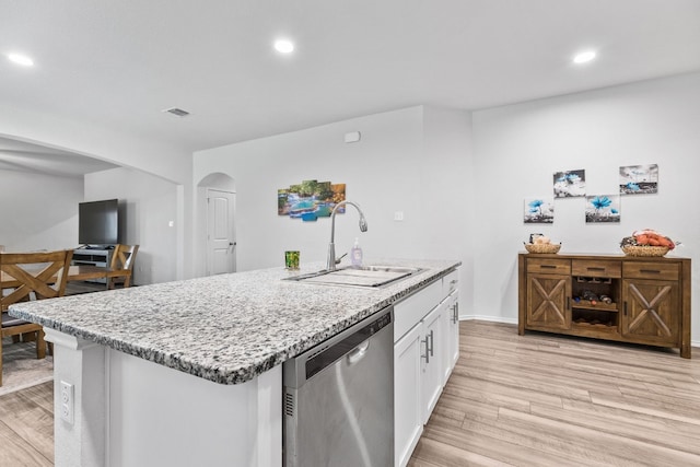 kitchen featuring sink, light hardwood / wood-style flooring, a kitchen island with sink, white cabinets, and stainless steel dishwasher