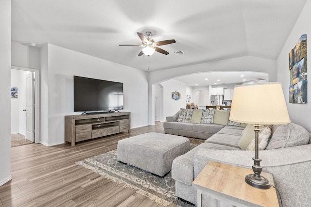living room featuring hardwood / wood-style flooring, vaulted ceiling, and ceiling fan