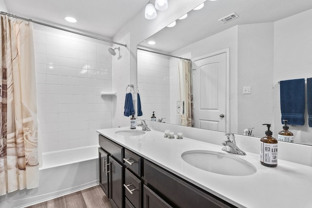 bathroom with hardwood / wood-style flooring, vanity, and shower / bathtub combination with curtain