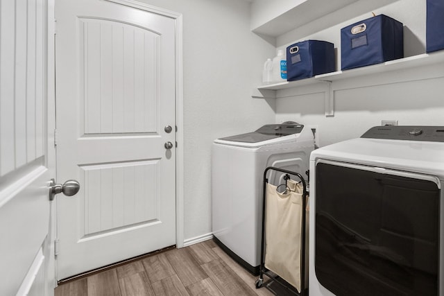 laundry room featuring washer and clothes dryer and light wood-type flooring