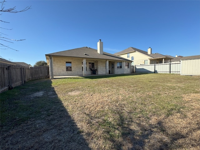 rear view of property with a lawn