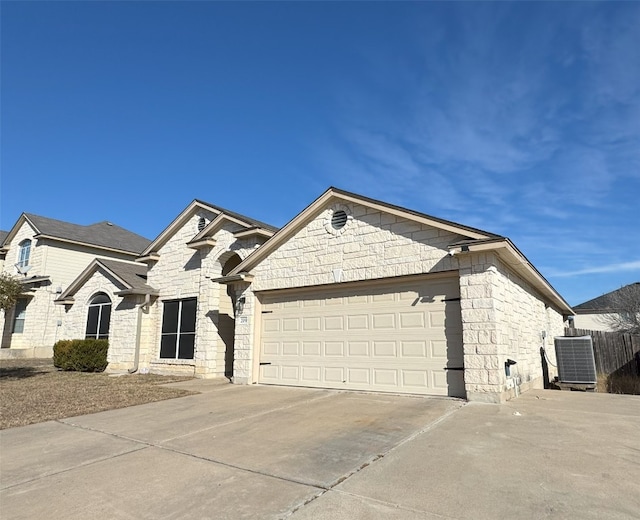 view of front of home featuring a garage and cooling unit