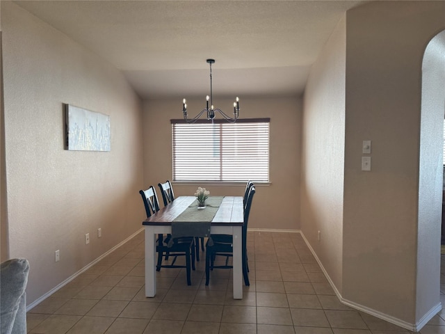 tiled dining room with a notable chandelier