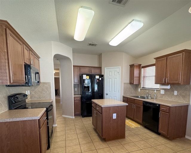 kitchen with lofted ceiling, sink, a center island, black appliances, and light tile patterned flooring