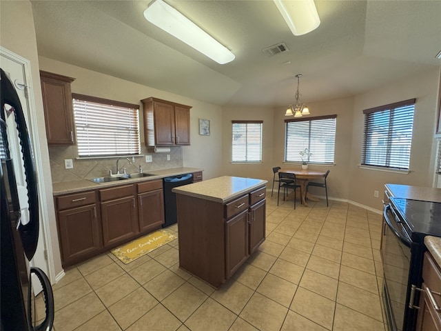 kitchen with a kitchen island, pendant lighting, sink, decorative backsplash, and black appliances