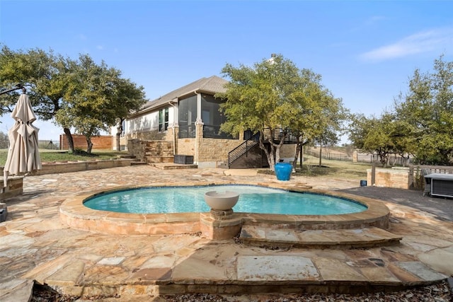 view of swimming pool with a jacuzzi, a sunroom, cooling unit, and fence