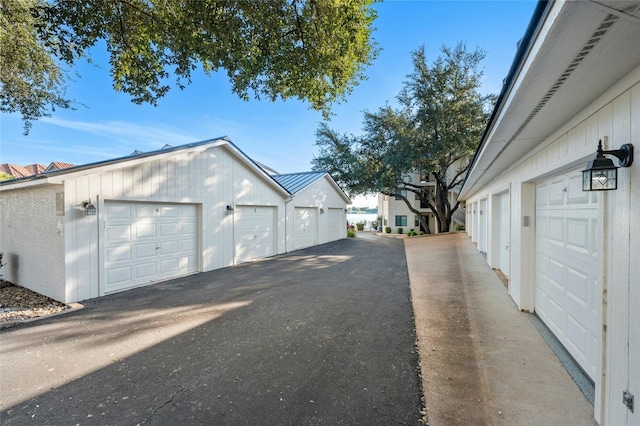 view of side of home featuring a standing seam roof, board and batten siding, an outbuilding, and metal roof
