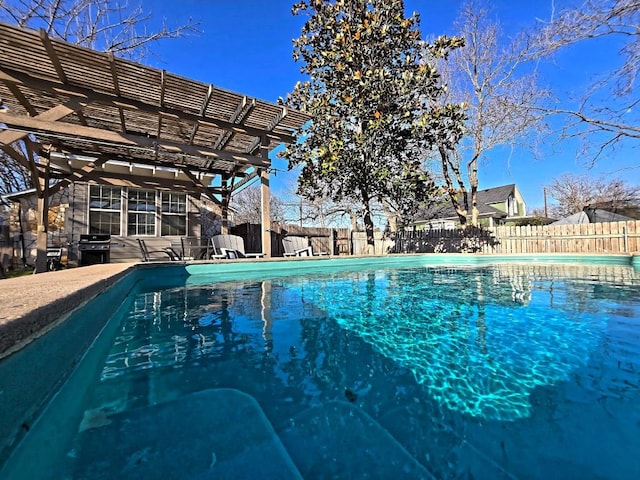 view of swimming pool featuring grilling area and a pergola