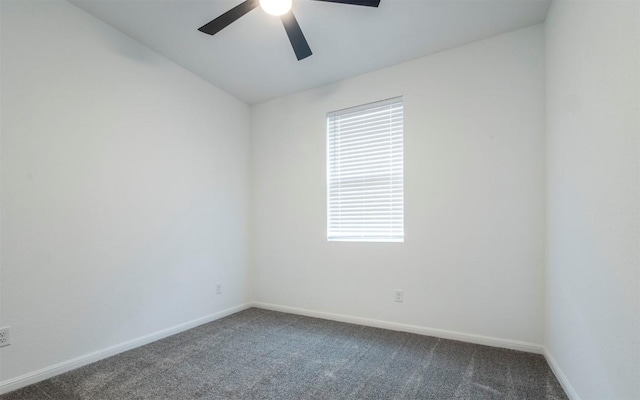 spare room featuring lofted ceiling, baseboards, dark colored carpet, and a ceiling fan