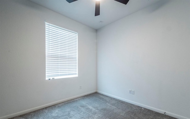 empty room with carpet floors, a ceiling fan, and baseboards