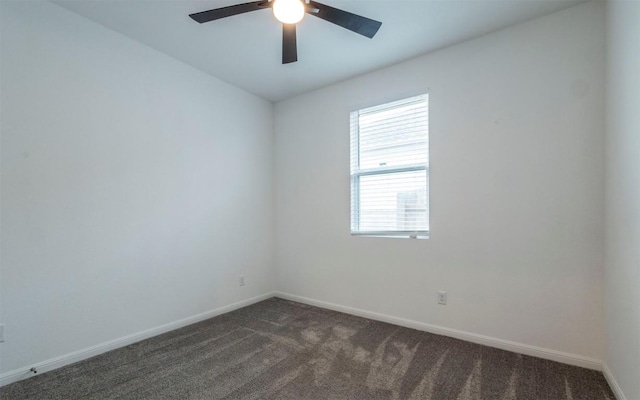 unfurnished room with ceiling fan, dark colored carpet, and baseboards