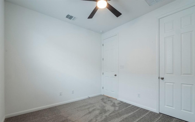 empty room featuring baseboards, visible vents, ceiling fan, and carpet flooring