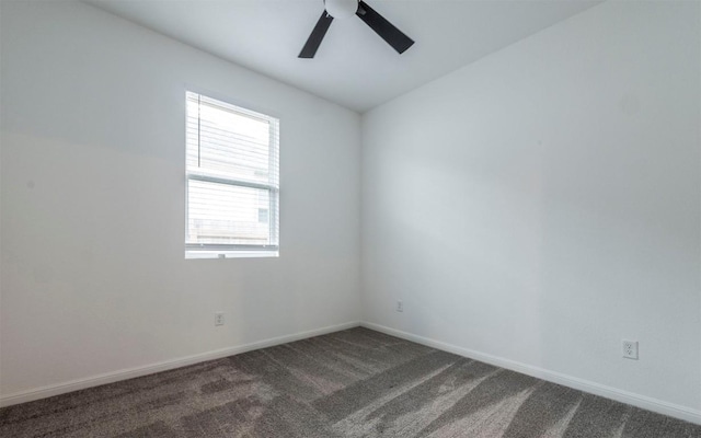 spare room with carpet floors, vaulted ceiling, baseboards, and a ceiling fan