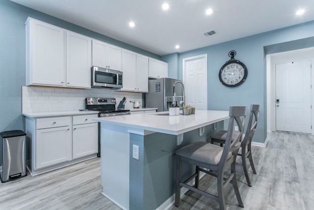 228 Citation Dr, Jarrell, TX 76537 - kitchen featuring stainless steel appliances, an island with sink, a sink, decorative backsplash, and a kitchen bar