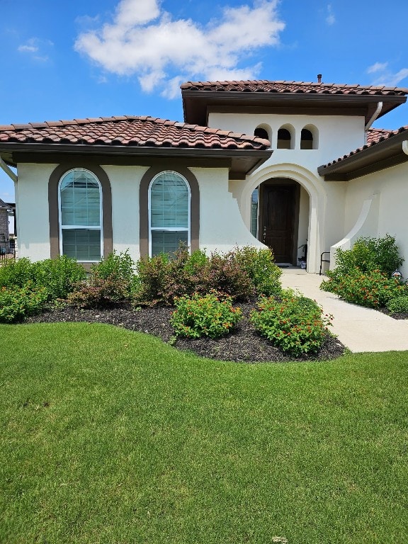 view of exterior entry featuring a yard