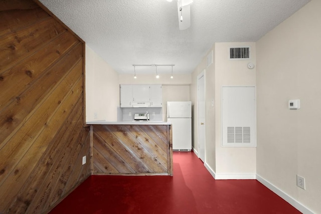 4205 Speedway Ave Unit 204, Austin, TX 78751 - kitchen with freestanding refrigerator, track lighting, a peninsula, a textured ceiling, and white cabinets