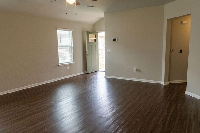 empty room featuring ceiling fan, dark hardwood / wood-style floors, and vaulted ceiling