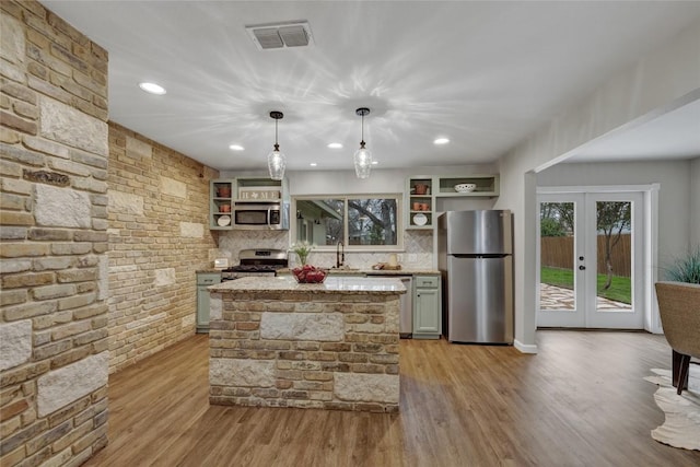 902 W Mill St, New Braunfels, TX 78130 - kitchen featuring appliances with stainless steel finishes, decorative light fixtures, sink, light stone countertops, and french doors