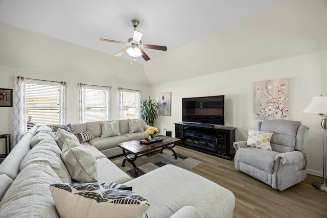 living room with ceiling fan, a healthy amount of sunlight, vaulted ceiling, and light wood-type flooring