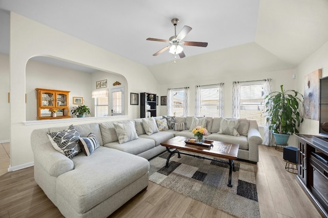 living room with lofted ceiling, light hardwood / wood-style flooring, and ceiling fan