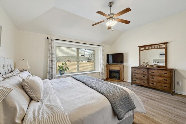 1017 Matheson Dr, Leander, TX 78641 - bedroom with lofted ceiling, a fireplace, light wood finished floors, baseboards, and a ceiling fan