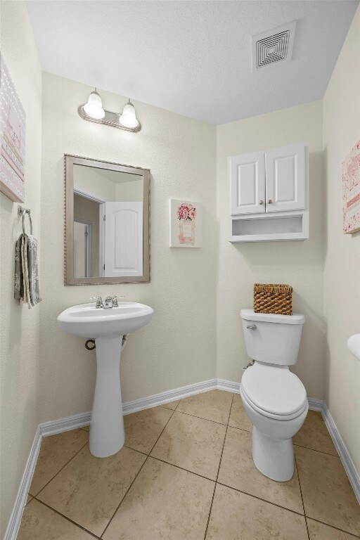 1017 Matheson Dr, Leander, TX 78641 - half bathroom with toilet, tile patterned floors, and baseboards