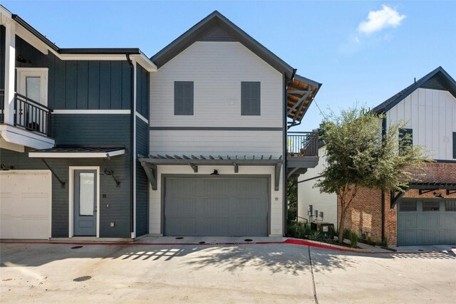 3809 Valley View Rd Unit 19, Austin, TX 78704 - view of property featuring a balcony, board and batten siding, driveway, and an attached garage