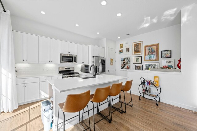 3809 Valley View Rd Unit 19, Austin, TX 78704 - kitchen featuring stainless steel appliances, a sink, decorative backsplash, light countertops, and a breakfast bar