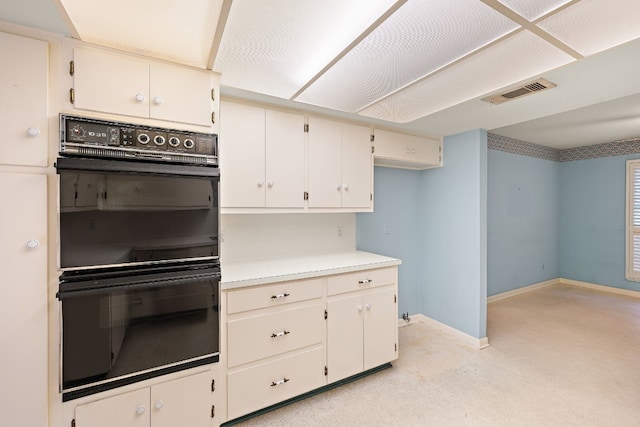 kitchen with white cabinetry and black double oven