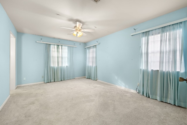 carpeted spare room featuring ceiling fan