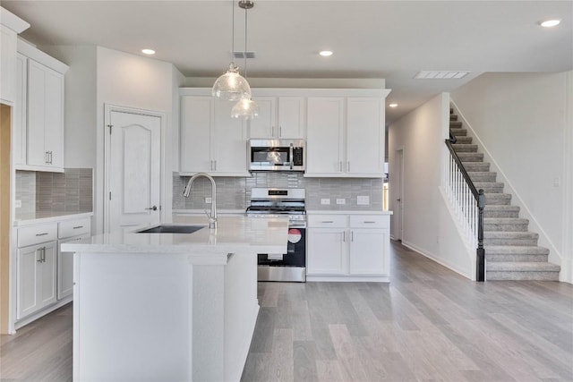 kitchen featuring appliances with stainless steel finishes, light countertops, visible vents, and light wood-type flooring