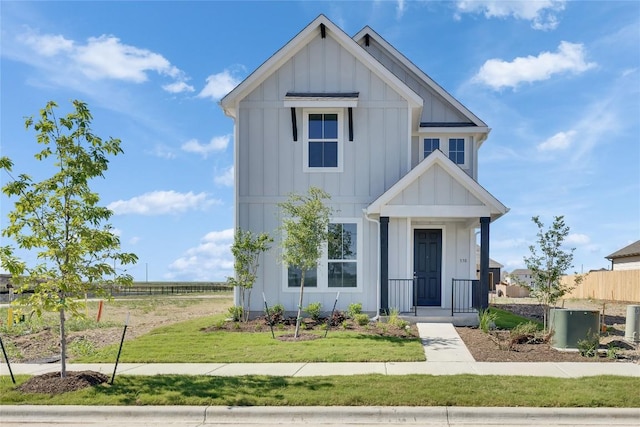 modern inspired farmhouse featuring a front lawn, fence, and board and batten siding