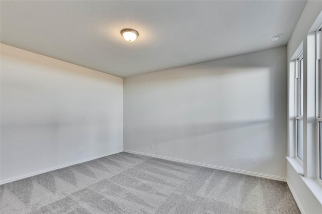 carpeted empty room with baseboards