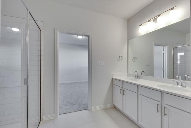 full bath with baseboards, a sink, double vanity, and a stall shower