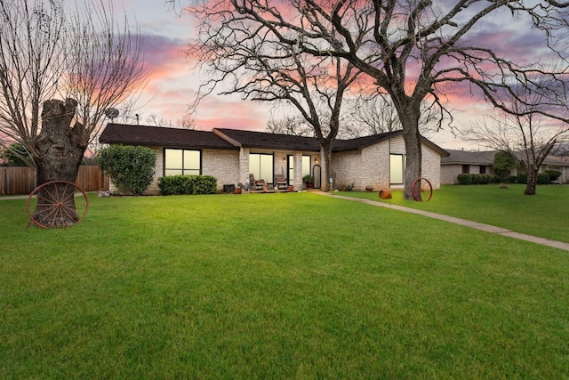 ranch-style home with a lawn